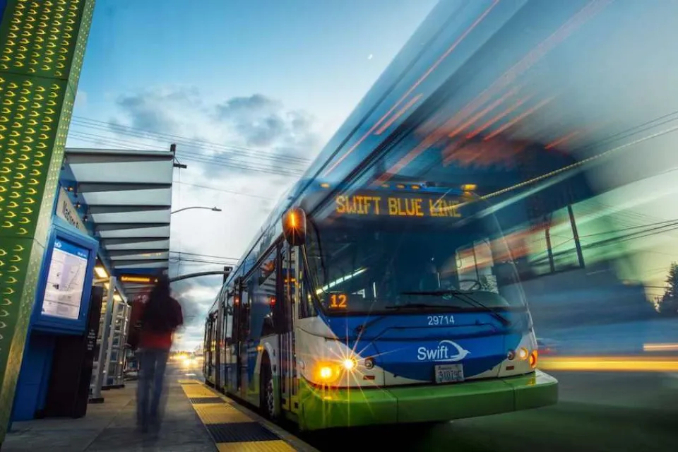 Low view looking up at bus rapid transit bus at station in Snohomish County, Washington with blur to indicate motion.